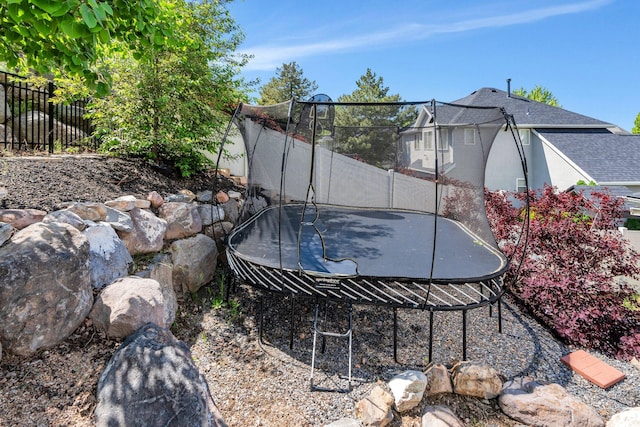 view of yard with a trampoline and fence