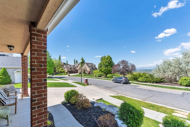 view of asphalt street with sidewalks and curbs