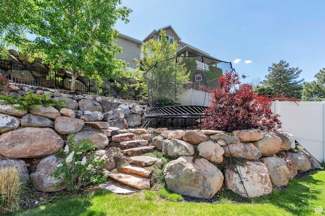 view of yard featuring fence and a trampoline