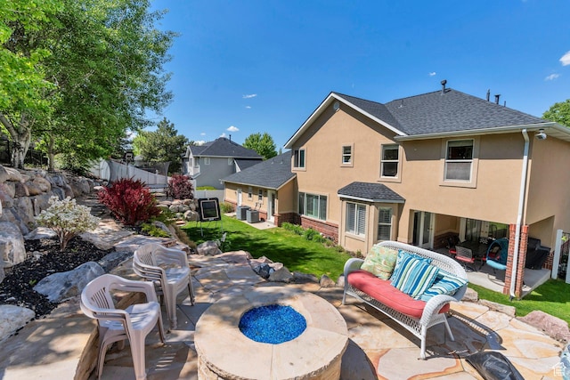 view of patio / terrace featuring an outdoor living space with a fire pit and central AC
