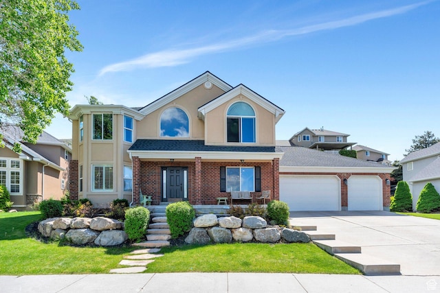 traditional-style house featuring a garage, concrete driveway, covered porch, stucco siding, and roof with shingles