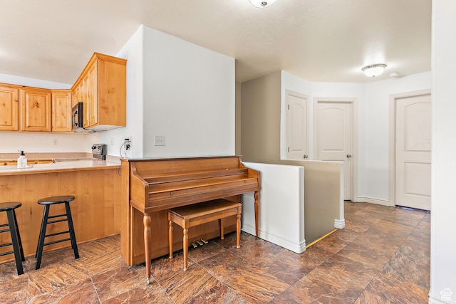 3123 E Canyon Glen Loop S, Spanish Fork, UT 84660 - kitchen with black microwave, stove, a kitchen bar, light countertops, and a peninsula