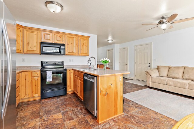3123 E Canyon Glen Loop S, Spanish Fork, UT 84660 - kitchen with black appliances, a sink, a peninsula, open floor plan, and stone tile floors