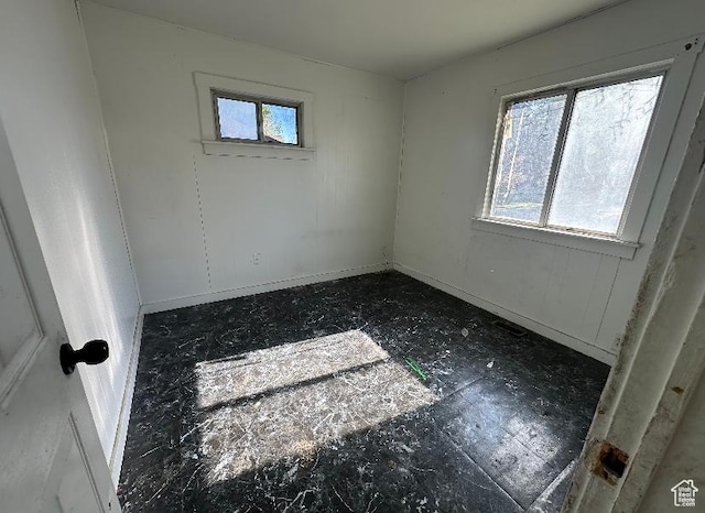 empty room featuring healthy amount of natural light and baseboards