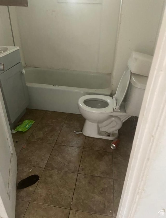full bathroom featuring toilet, tile patterned floors, a bathtub, and vanity