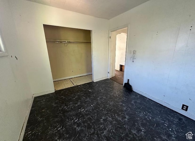 unfurnished bedroom featuring baseboards and a closet