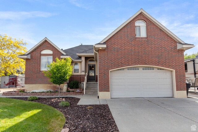 1768 N 200 W, North Ogden, UT 84414 - view of front of house with concrete driveway, brick siding, a garage, and a shingled roof