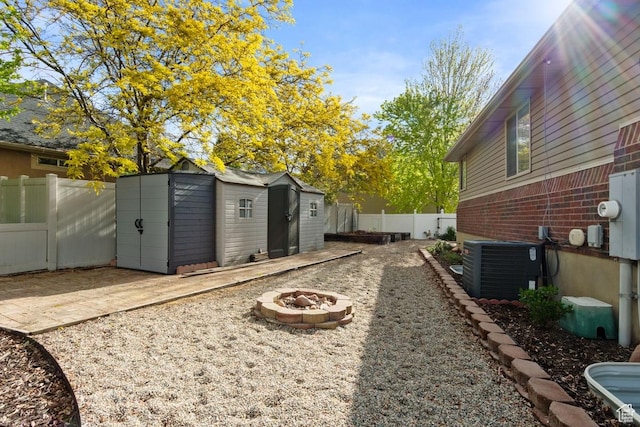 1768 N 200 W, North Ogden, UT 84414 - fenced backyard with a fire pit, a shed, central air condition unit, an outbuilding, and a patio