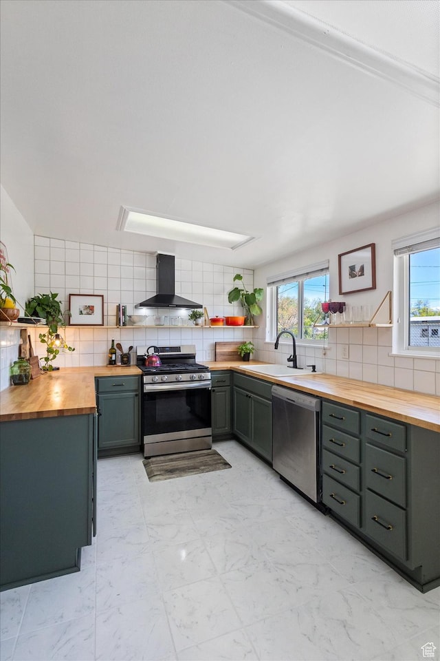 944 N 1400 W, Salt Lake City, UT 84116 - kitchen featuring butcher block countertops, appliances with stainless steel finishes, wall chimney range hood, tasteful backsplash, and gray cabinets