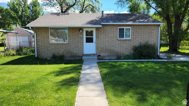 bungalow-style house with a shingled roof and brick siding