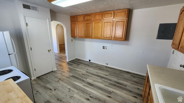 washroom with hookup for a gas dryer, electric panel, arched walkways, washer hookup, and light wood-style floors