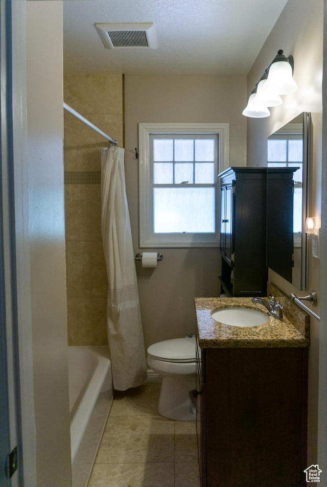 full bathroom featuring healthy amount of natural light, tile patterned flooring, vanity, and toilet