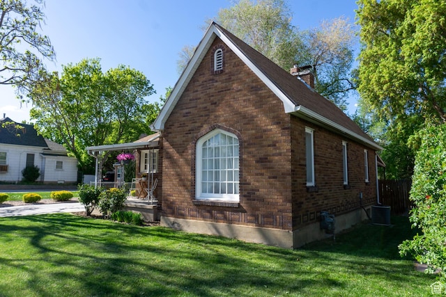view of home's exterior featuring a lawn, a chimney, brick siding, and central air condition unit