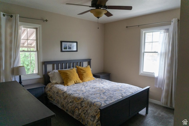 bedroom featuring dark carpet, a ceiling fan, and baseboards