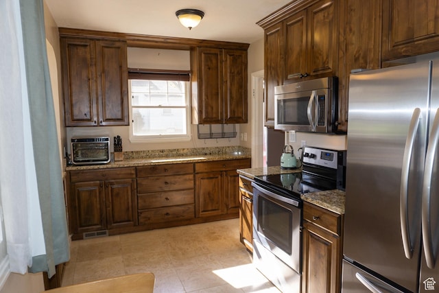 kitchen featuring stainless steel appliances and light stone countertops