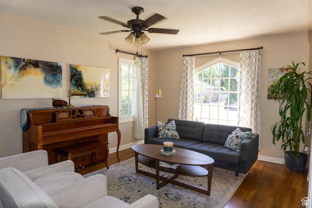 living area featuring baseboards, wood finished floors, and ceiling fan