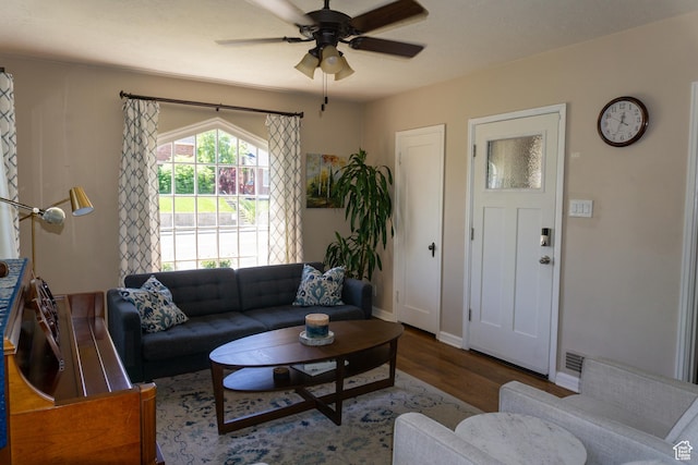 living room with wood finished floors, ceiling fan, and baseboards