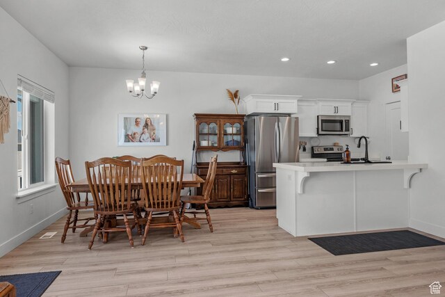 dining space featuring a chandelier, recessed lighting, light wood finished floors, and baseboards