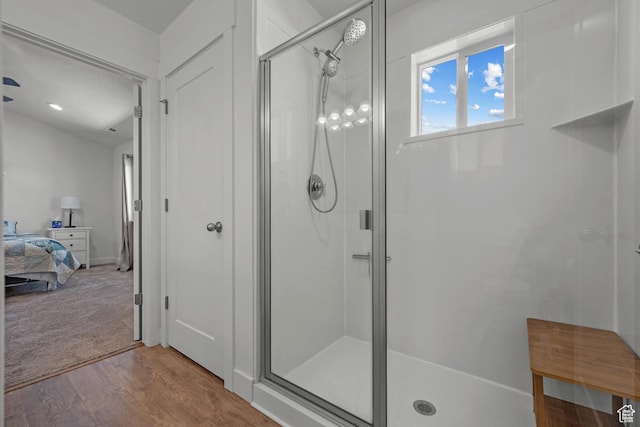 full bath with a stall shower, wood finished floors, and connected bathroom