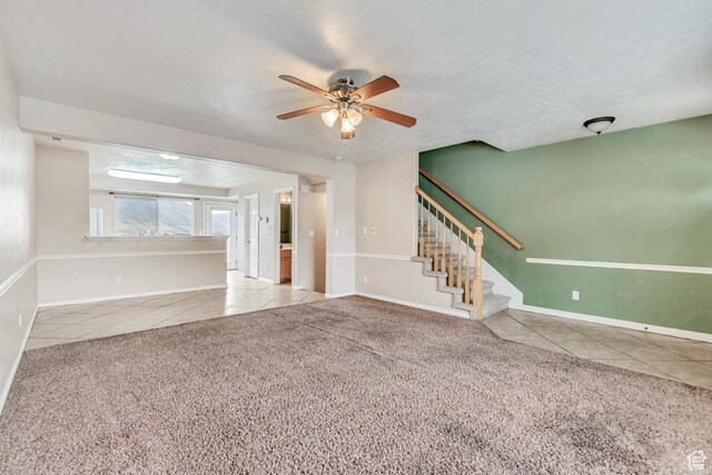 768 E 1740 S Unit 768, Orem, UT 84097 - unfurnished living room with tile patterned floors, ceiling fan, stairway, carpet flooring, and baseboards