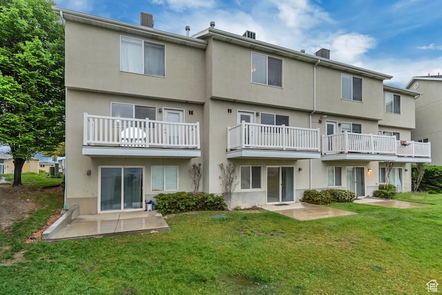 back of property featuring stucco siding, a patio area, and a yard