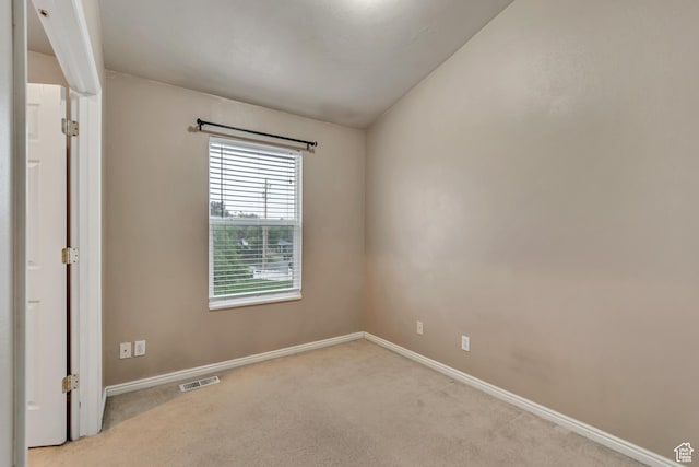 unfurnished room featuring light colored carpet and baseboards
