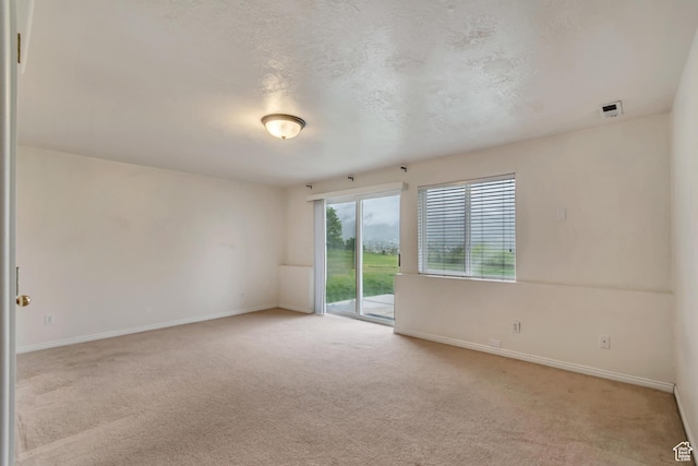 carpeted empty room featuring baseboards