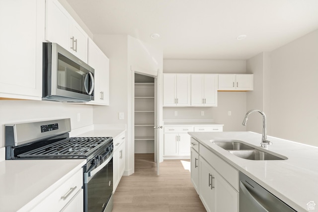 3523 N Browning St Unit 1233, Eagle Mountain, UT 84005 - kitchen with appliances with stainless steel finishes, light wood-style floors, light countertops, and white cabinetry