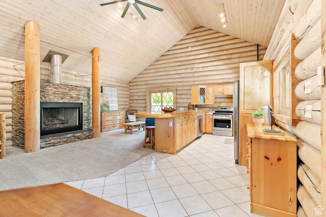 kitchen featuring log walls, wood counters, stainless steel appliances, light brown cabinets, and ceiling fan