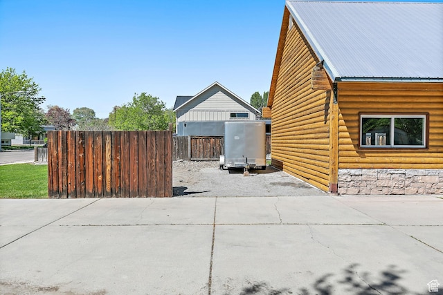 view of side of property with fence and metal roof