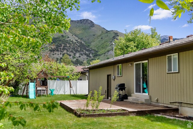 rear view of property with a mountain view, a playground, and entry steps