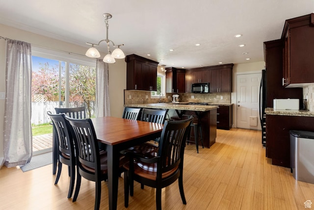 dining area with light wood-style flooring, plenty of natural light, a chandelier, and recessed lighting