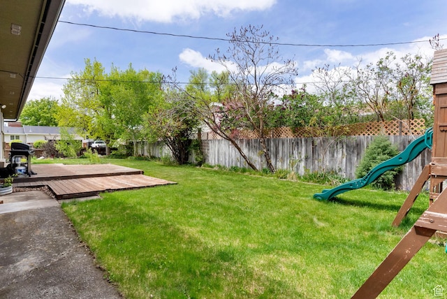 view of yard featuring a wooden deck and a playground