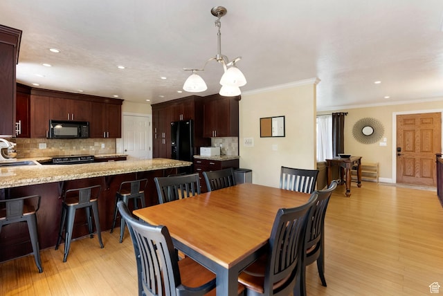 dining area with recessed lighting, ornamental molding, light wood-style flooring, and a chandelier