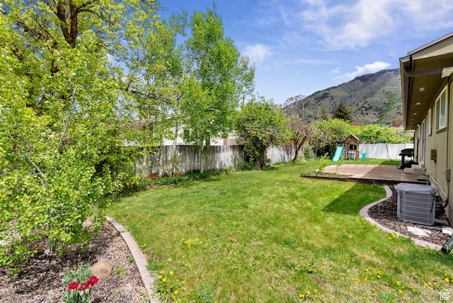 view of yard with cooling unit and a deck with mountain view