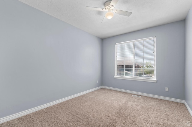 carpeted spare room with baseboards, a textured ceiling, and ceiling fan