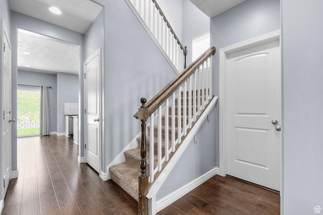 stairway with wood finished floors and baseboards