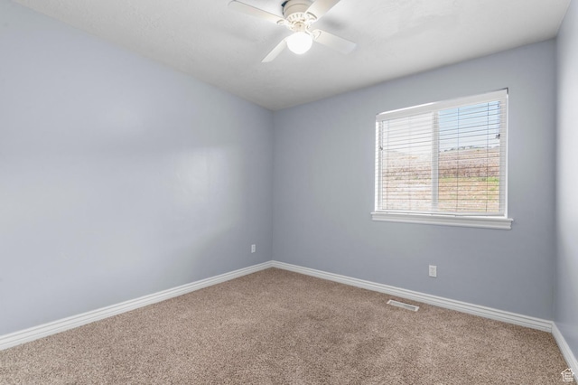 carpeted empty room with ceiling fan and baseboards