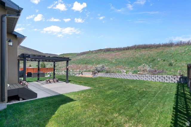 view of grassy yard with a pergola, a patio area, and a mountain view