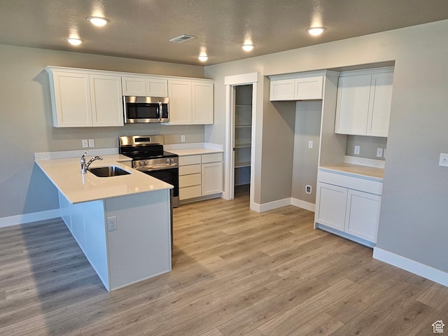 542 N 1400 W Lot 29, Springville, UT 84663 - kitchen with stainless steel appliances, a sink, baseboards, a peninsula, and white cabinets