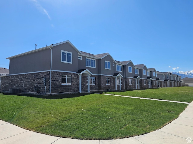 542 N 1400 W Lot 29, Springville, UT 84663 - view of front of property featuring a front yard, brick siding, a residential view, central AC unit, and stucco siding