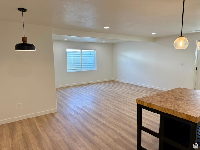 167 E Craner Peak Dr, Eagle Mountain, UT 84005 - unfurnished living room with light wood-type flooring, baseboards, recessed lighting, and a textured ceiling