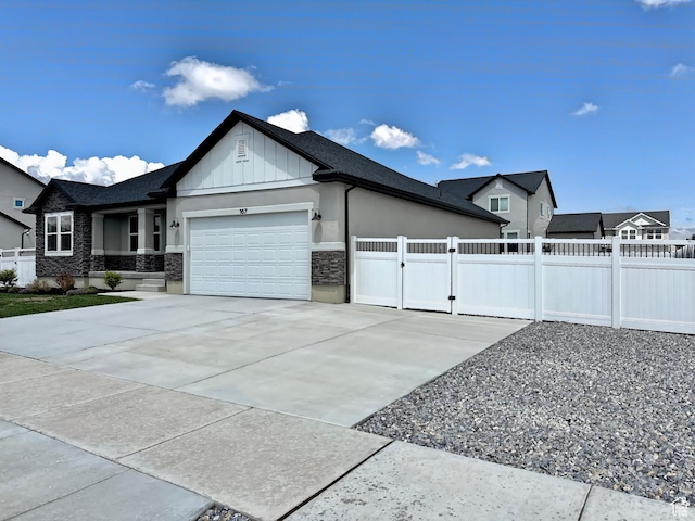 167 E Craner Peak Dr, Eagle Mountain, UT 84005 - view of home's exterior featuring an attached garage, fence, stone siding, board and batten siding, and a gate