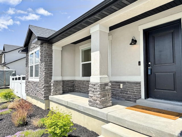 167 E Craner Peak Dr, Eagle Mountain, UT 84005 - doorway to property featuring stone siding, stucco siding, fence, and a porch