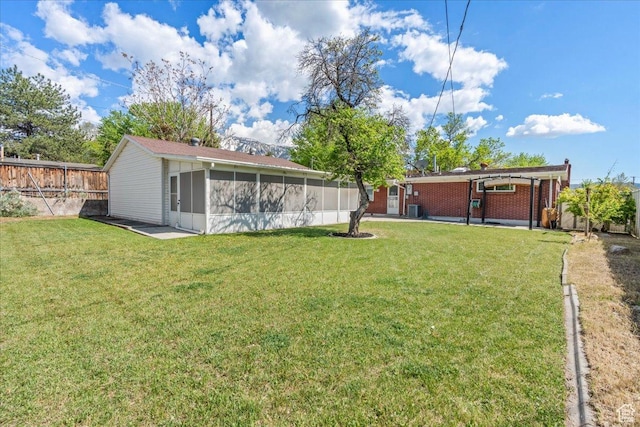view of yard with a sunroom and central air condition unit