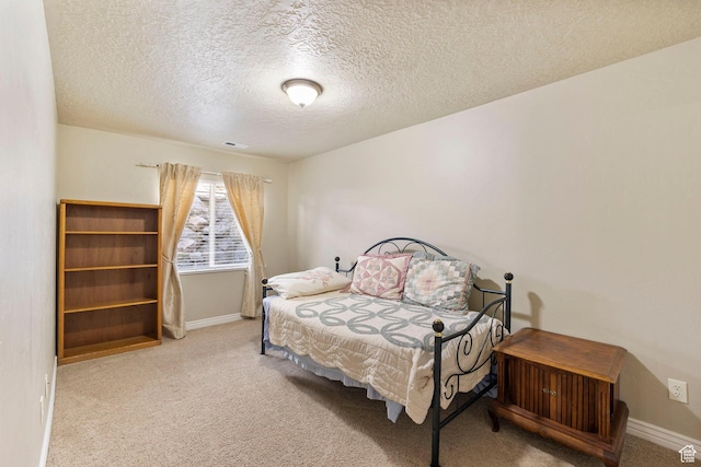 bedroom with carpet, a textured ceiling, and baseboards
