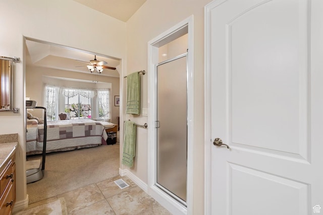ensuite bathroom featuring vanity, a shower stall, a ceiling fan, and tile patterned flooring