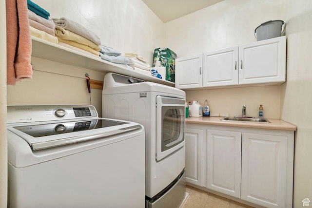 washroom with washing machine and clothes dryer, cabinet space, and light tile patterned floors