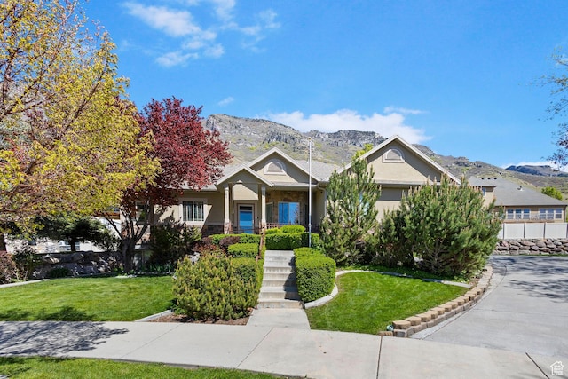 view of front of home with a mountain view, a front lawn, and stucco siding