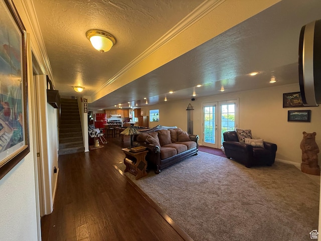 living area with crown molding, stairs, a textured ceiling, dark wood-type flooring, and baseboards